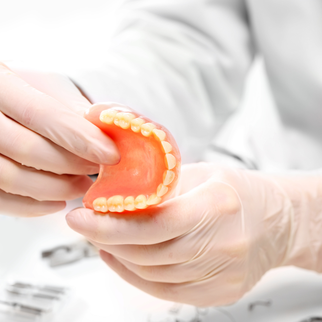 Denture held by a dental technician